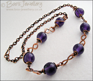 Purple glass bead necklace with copper hammered figure of 8 links