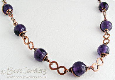 Purple glass bead necklace with copper hammered figure of 8 links