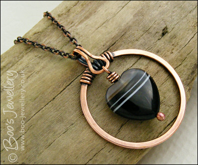 Antiqued copper circle pendant with banded black heart gemstone