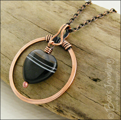 Antiqued copper circle pendant with banded black heart gemstone