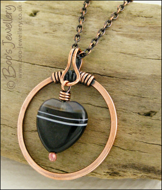 Antiqued copper circle pendant with banded black heart gemstone