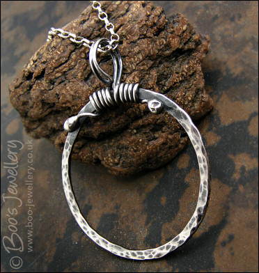 Hammered silver circle pendant with tendril bail