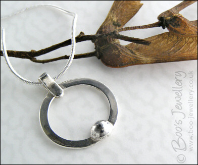 Hammered silver circle pendant with silver pebble
