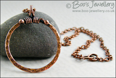 Hammered copper circle pendant with tendril bail