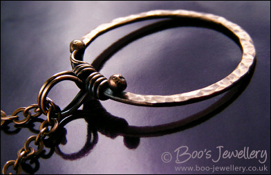 Hammered copper circle pendant with tendril bail